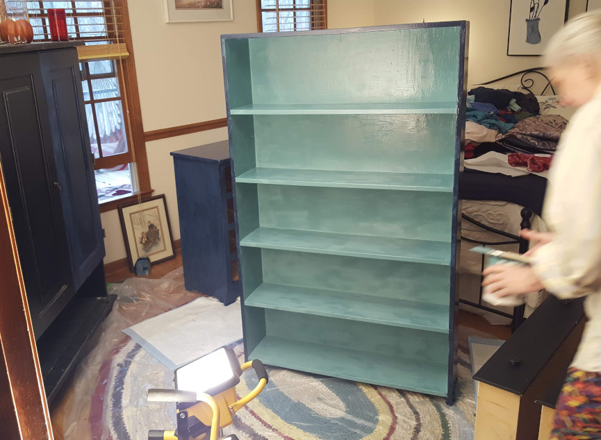 First coat of blue paint on a bookcase.
