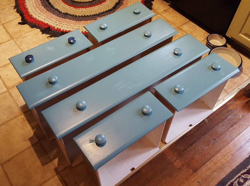 Drawers, freshly painted, lined up to dry.