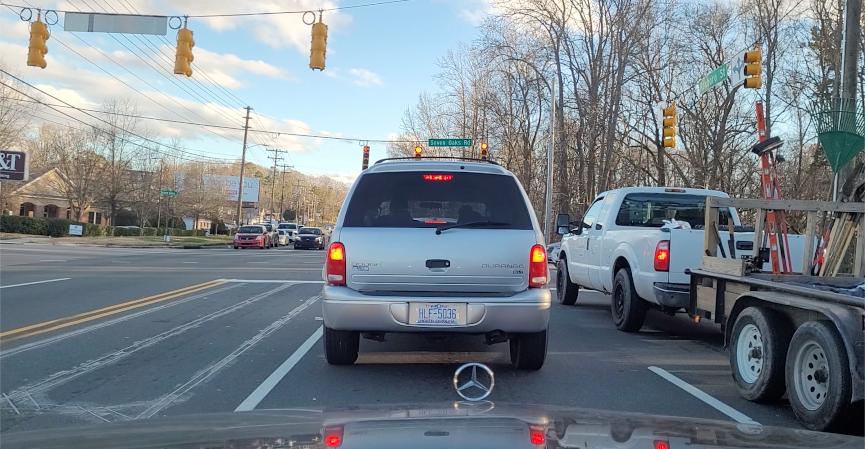 Stopped at a traffic light behind a vehicle.
