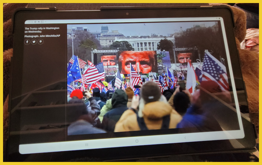 Atablet showing a photograph from a Trump rally, January 6, 2021.
