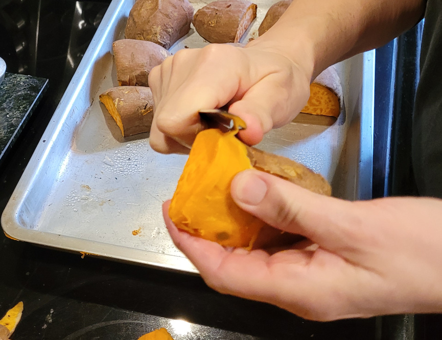 Peeling a baked sweet potato.