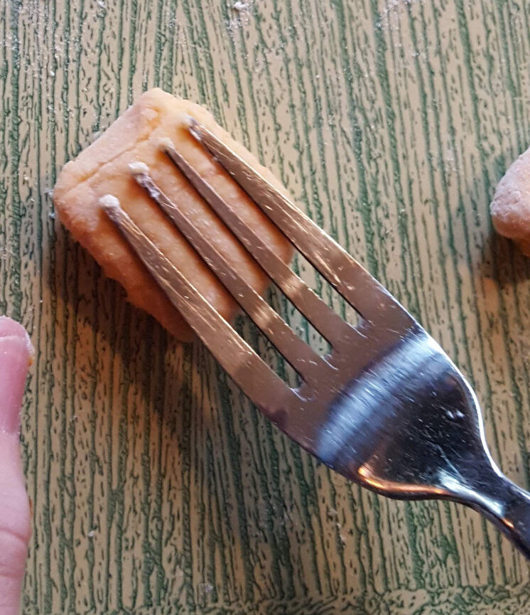 Pressing a gnocchi with a fork.