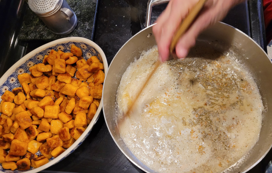 Oven top with pan of sauce and sweet potato gnocchi