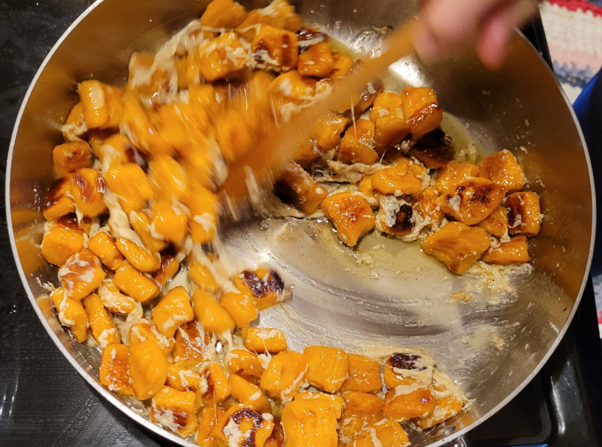 A pan with orange sweet potato gnocchi.