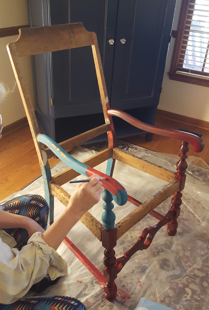 A restored chair being painted.