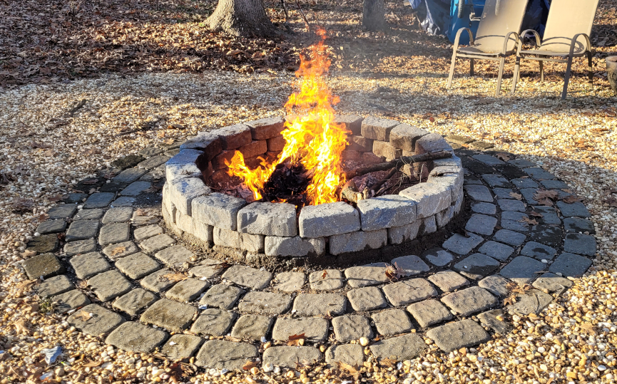 A fire pit burning wood and cardboard