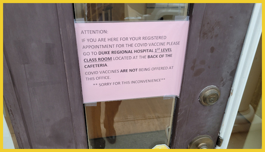 Sign on door telling people to go to another location for vaccination