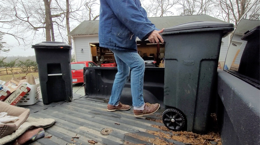putting a garbage can in a pickup truck bed