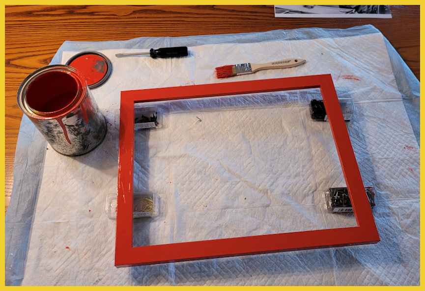 A picture frame is done being painted red