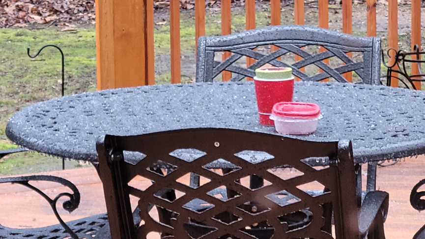 A deck table covered with icy sleet