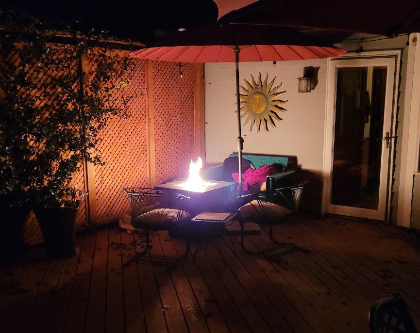 A corner of a deck with an outdoor fire.
